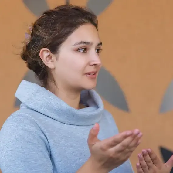 Profissional explicando um conceito com as mãos em movimento, destacando o atendimento consultivo da LCM Sistemas.